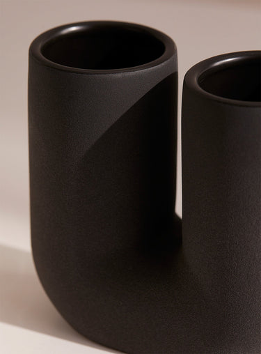 Black cylindrical toothbrush holder